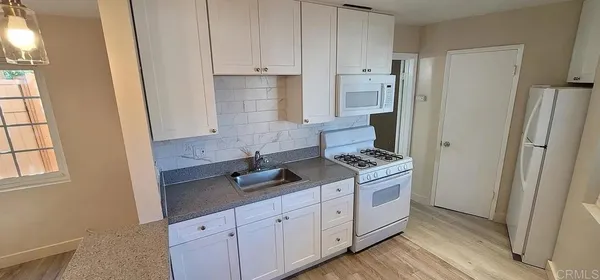 a kitchen with stainless steel appliances granite countertop a stove a refrigerator and a cabinets