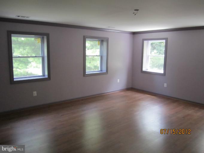 5129 Old National Pike Frederick, MD 21702 - Photo 5 of 14 a view of an empty room with wooden floor and a window
