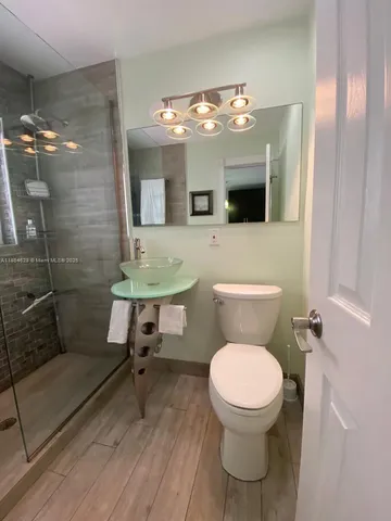 a bathroom with a toilet a sink and mirror