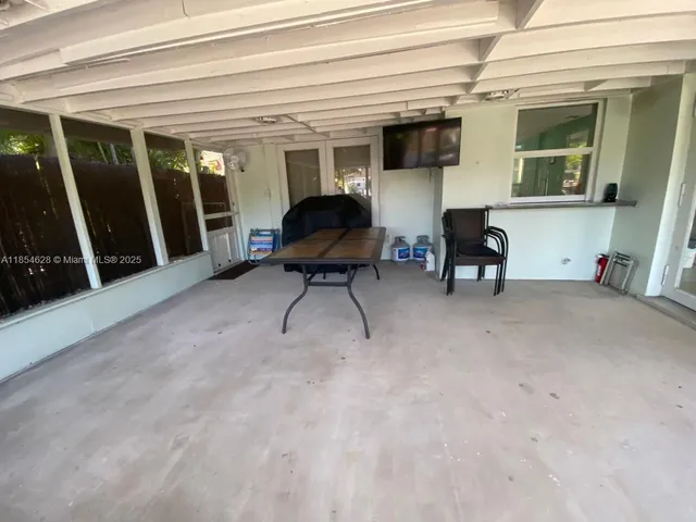 a living room with furniture a flat screen tv and a large window