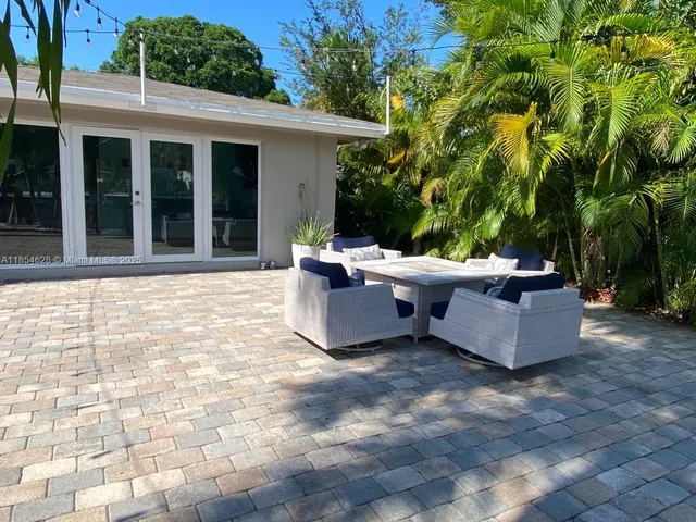 a view of a patio with table and chairs and potted plants