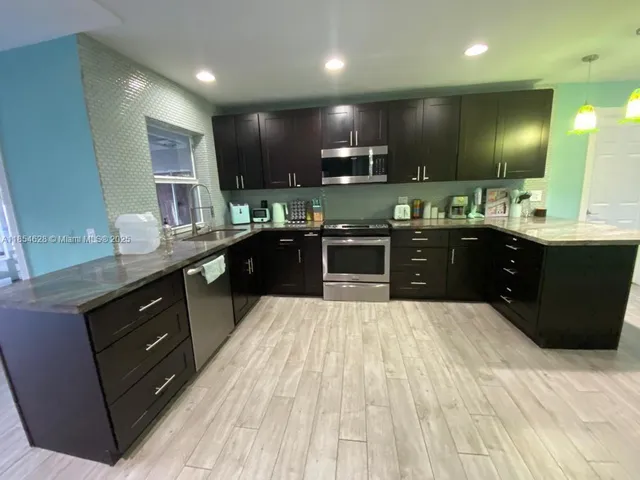 a large kitchen with wooden cabinets and stainless steel appliances