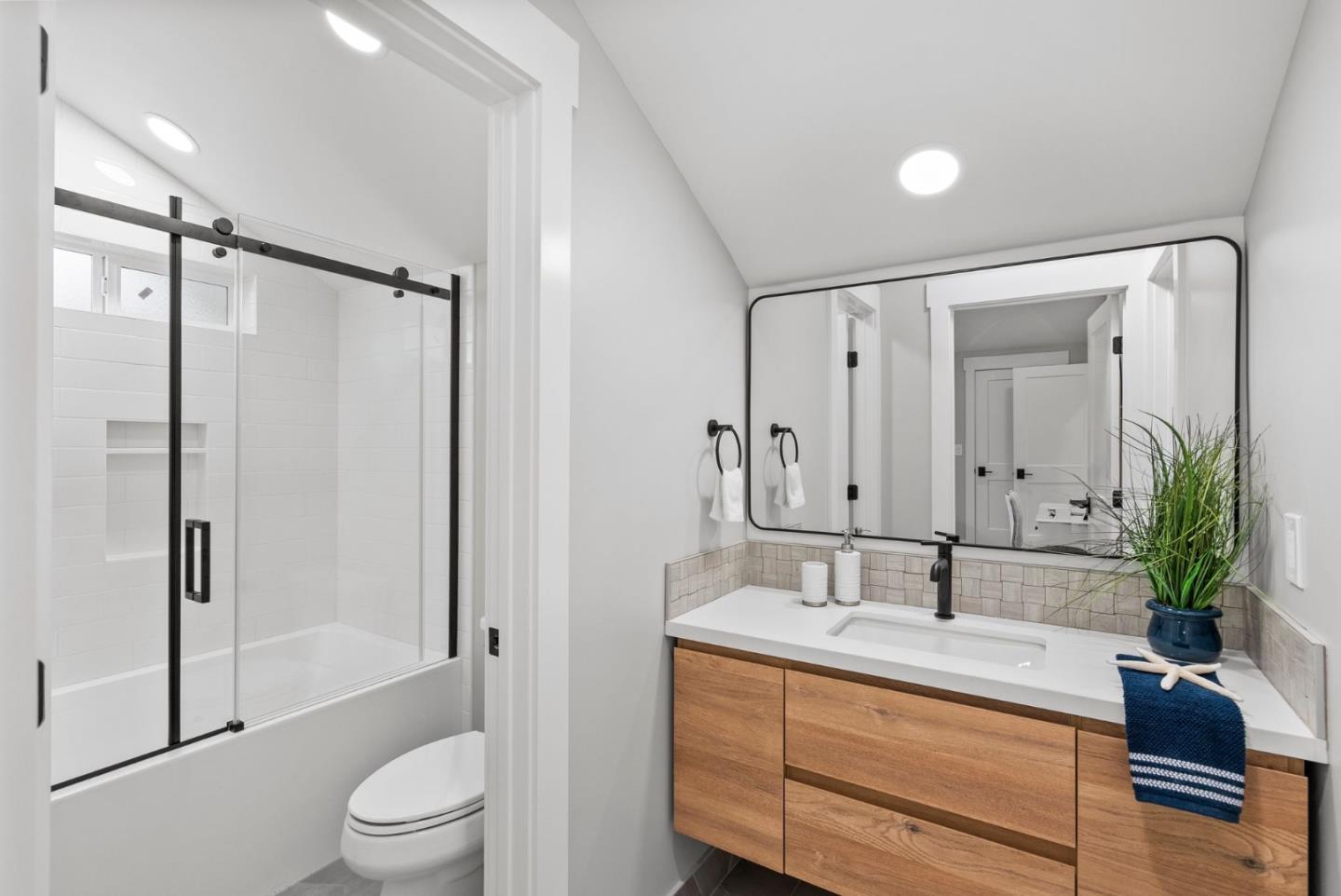 1587 Valota Road Redwood City, CA 94061 - Photo 24 of 42 a bathroom with a double vanity sink toilet mirror and shower