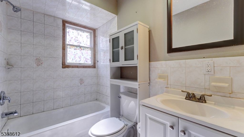 591 Cherry Street, Unit 1 Elizabeth, NJ 07208 - Photo 7 of 12 a bathroom with a sink toilet a mirror and shower