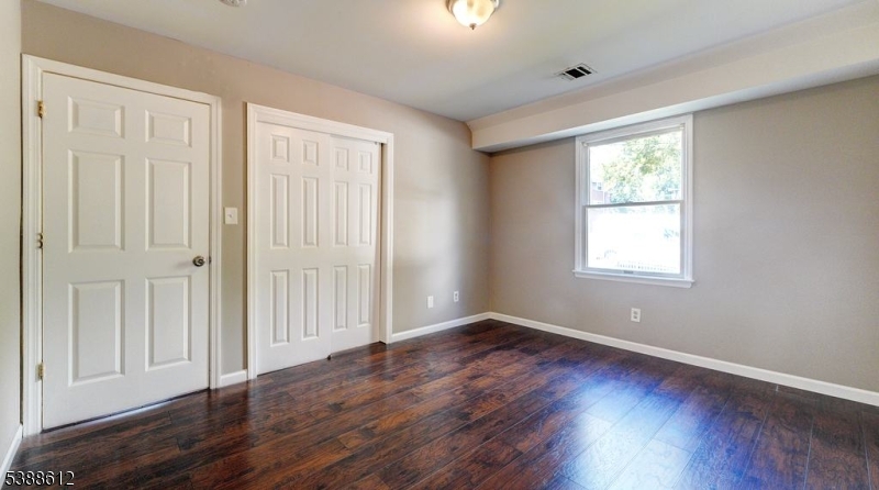 591 Cherry Street, Unit 1 Elizabeth, NJ 07208 - Photo 10 of 12 a view of an empty room with wooden floor and a window