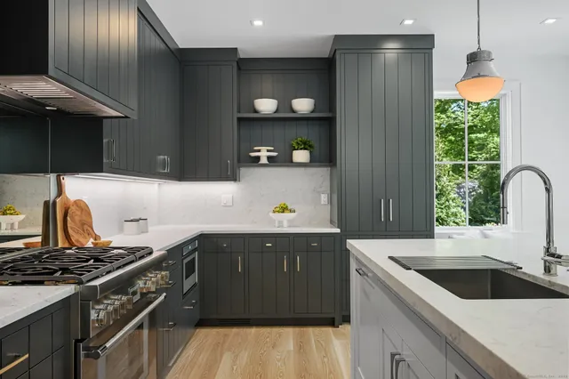 a kitchen with granite countertop a sink stainless steel appliances and cabinets