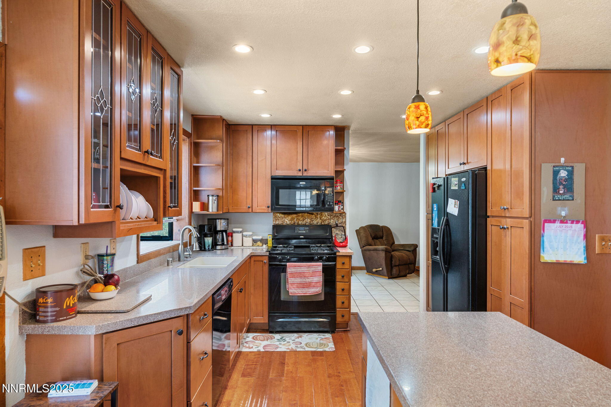 21615 Dortort Drive Reno, NV 89521 - Photo 21 of 52 a kitchen with stainless steel appliances granite countertop a refrigerator a sink dishwasher a stove and a dining table with wooden floor