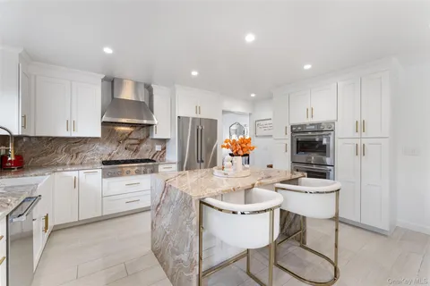 a kitchen with stainless steel appliances kitchen island granite countertop a sink and cabinets