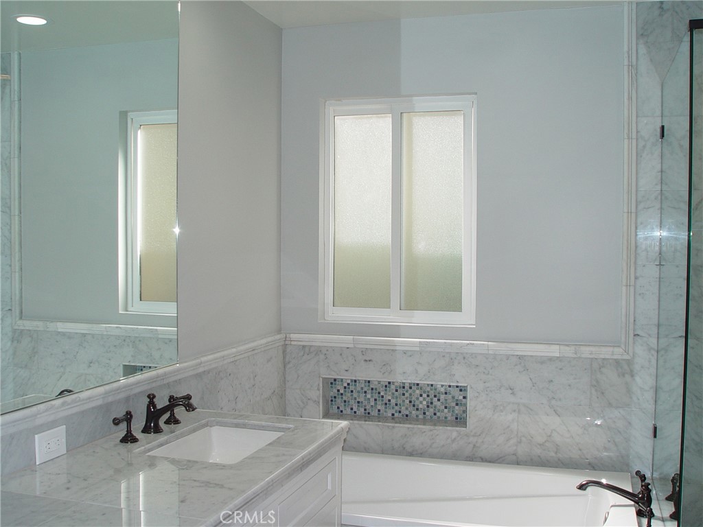 125 7th Street Manhattan Beach, CA 90266 - Photo 13 of 20 a bathroom with a granite countertop sink and a mirror