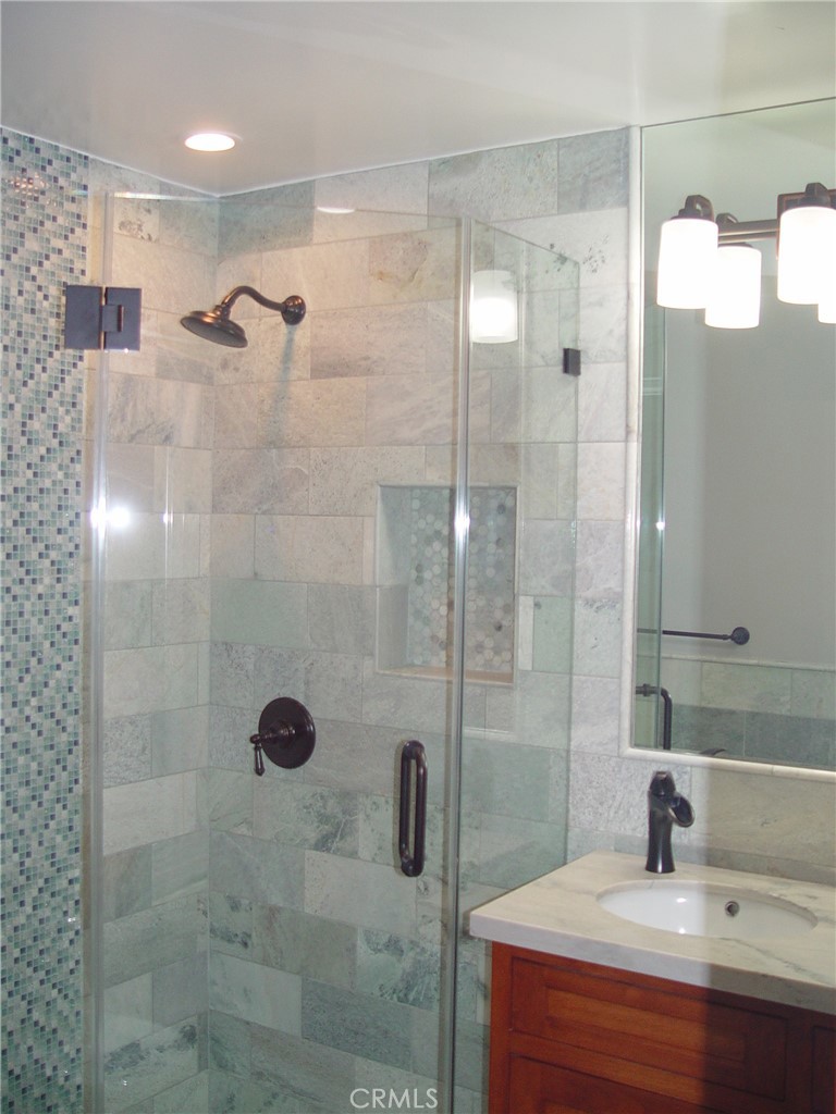 125 7th Street Manhattan Beach, CA 90266 - Photo 15 of 20 a bathroom with a shower sink and mirror