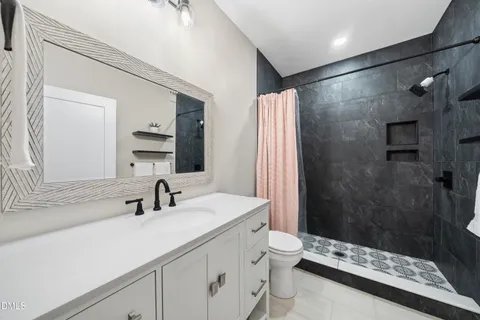 a bedroom with a bed and a large mirror