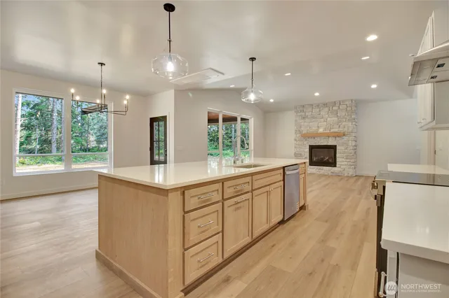 a kitchen with kitchen island granite countertop a stove oven and a wooden floors