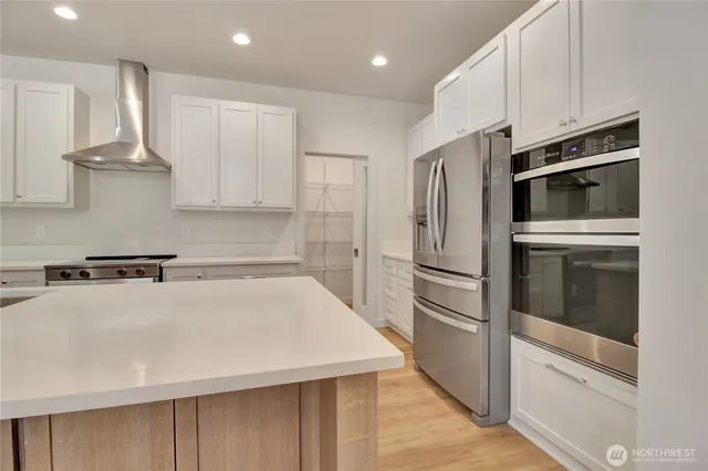 a kitchen with stainless steel appliances a refrigerator and a stove top oven