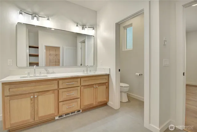 a spacious bathroom with a granite countertop sink toilet a large mirror a and shower