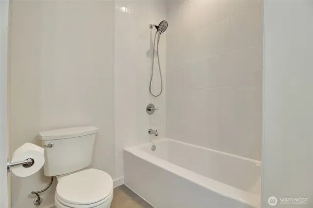 a white toilet sitting next to a bath tub