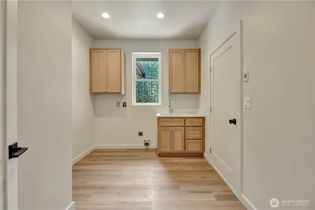 a view of a kitchen with a sink cabinets and wooden floor