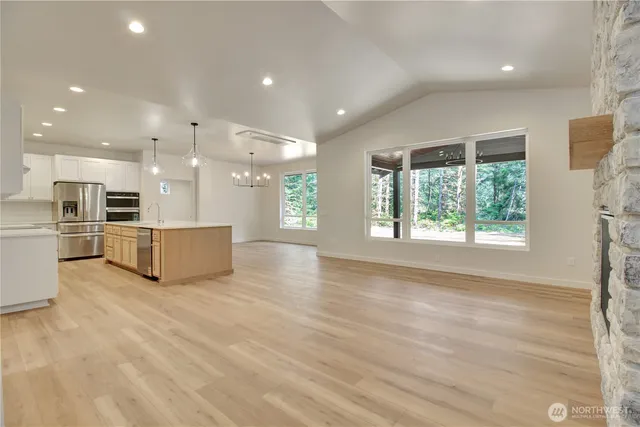 a view of kitchen with kitchen island wooden floor appliances and cabinets