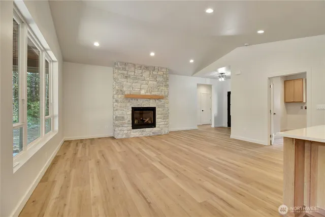 a view of empty room with wooden floor and fireplace
