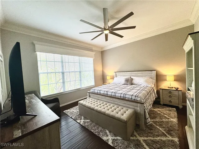 a bedroom with a large bed and a flat tv screen on dresser