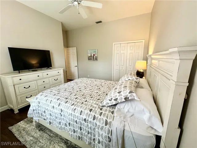 a bedroom with a flat screen tv on the dresser and a flat screen tv