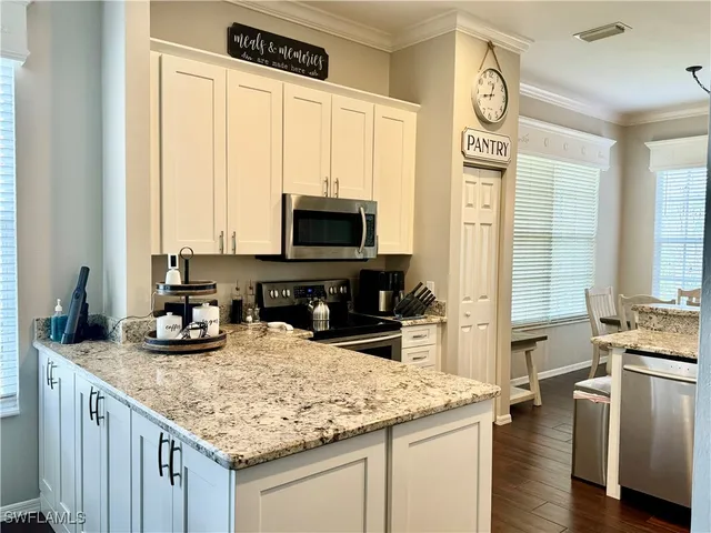 a kitchen with stainless steel appliances granite countertop a sink stove and cabinets