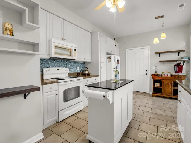 a kitchen with white cabinets and white appliances