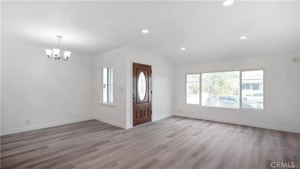 4249 Filhurst Avenue Baldwin Park, CA 91706 - Photo 3 of 24 an empty room with wooden floor chandelier and windows