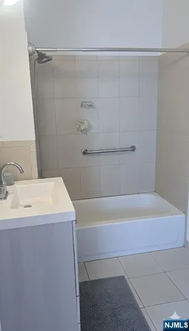 a bathroom with a tub a sink and a shower