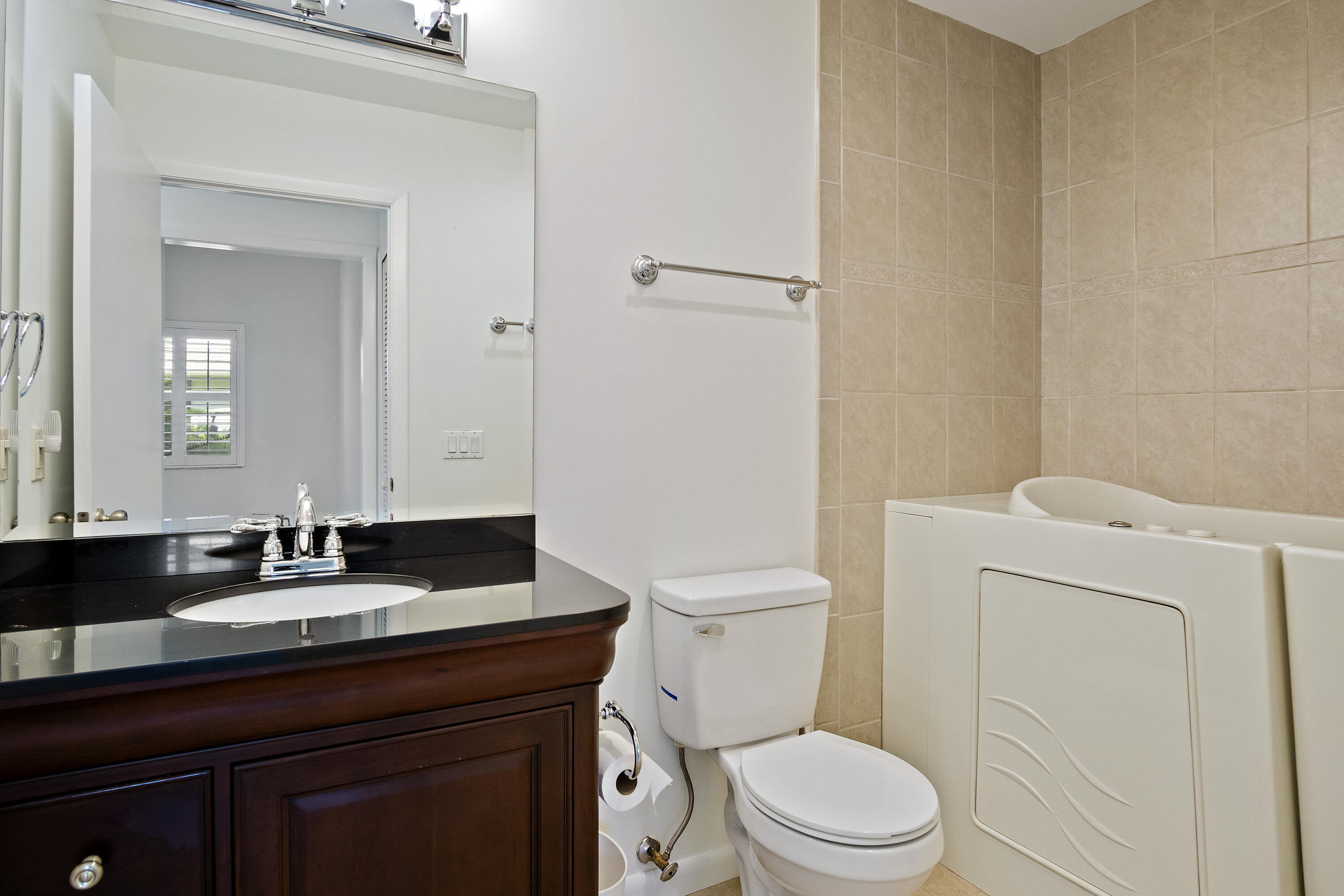 3782 Southeast Canvas Back Place Stuart, FL 34997 - Photo 14 of 19 a bathroom with a granite countertop toilet a sink and a mirror