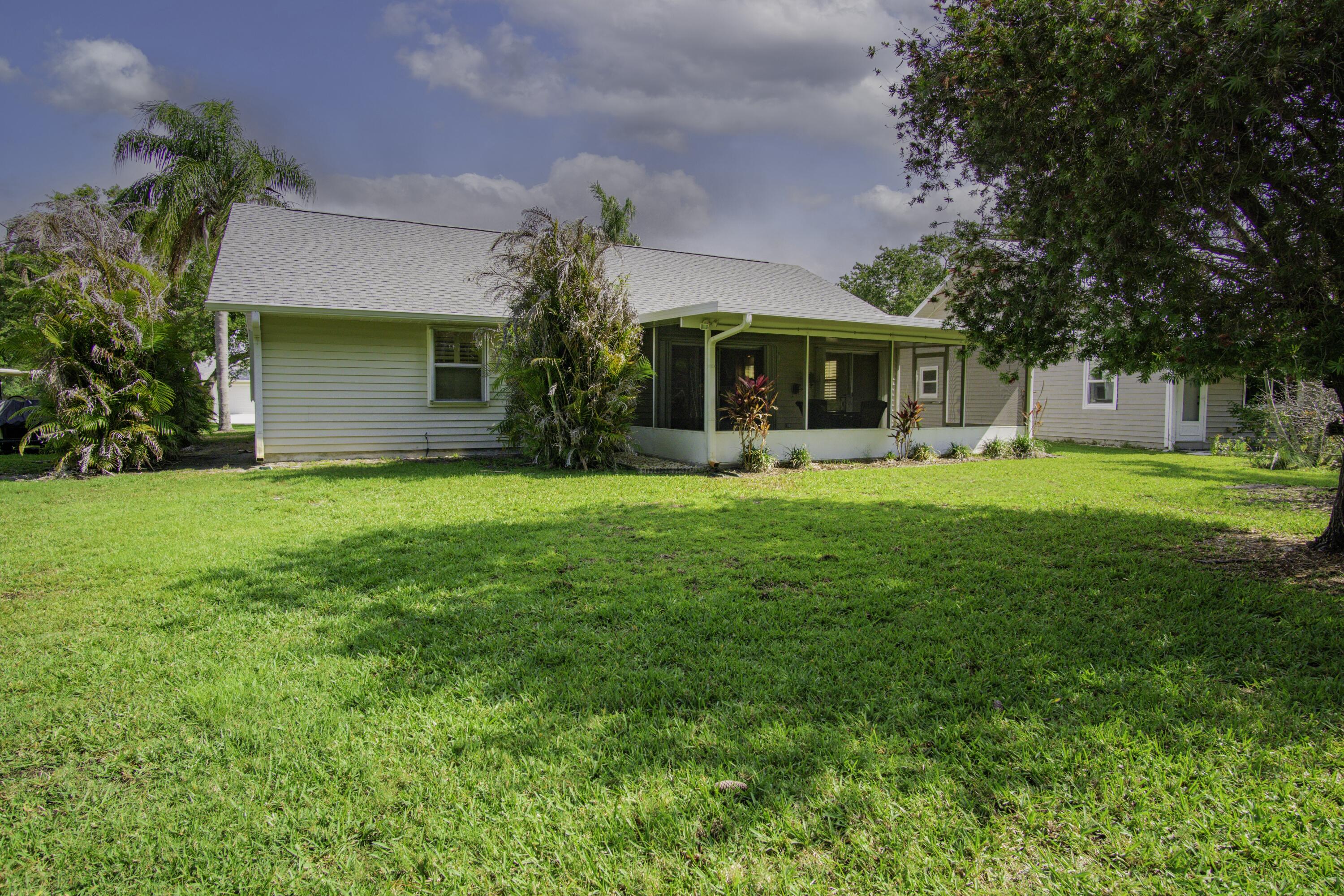 3782 Southeast Canvas Back Place Stuart, FL 34997 - Photo 16 of 19 a front view of a house with a yard and trees