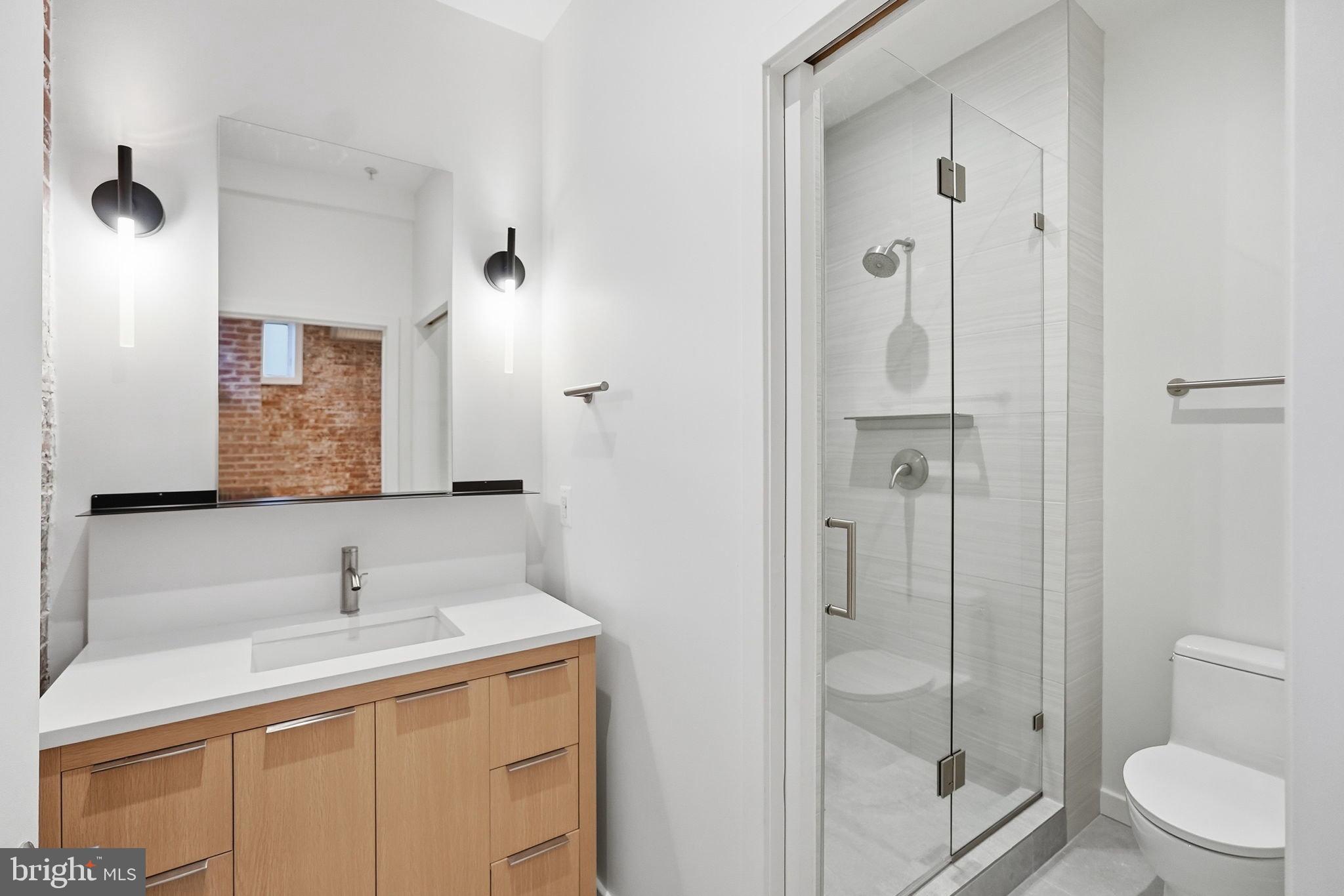 1209 13th Street Northwest, Unit 208 Washington, DC 20005 - Photo 13 of 22 a bathroom with a sink a toilet and shower