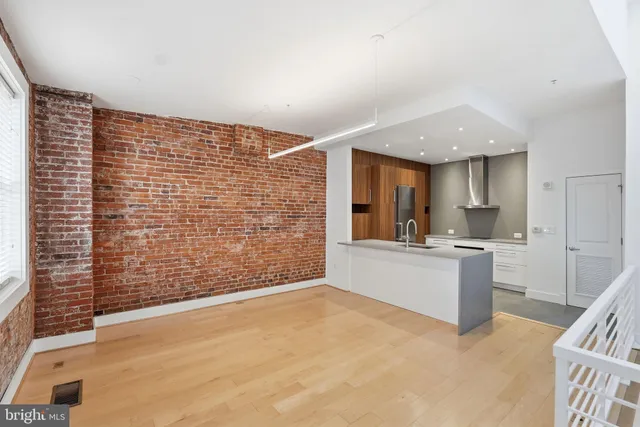 a view of kitchen with stainless steel appliances granite countertop refrigerator sink and cabinets