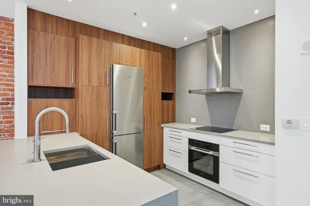 a kitchen with stainless steel appliances granite countertop a sink and a refrigerator