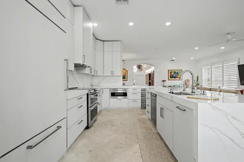 a kitchen with white cabinets appliances and sink
