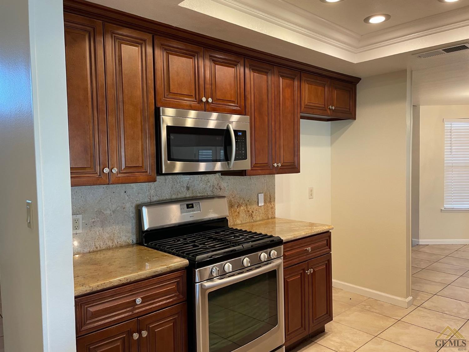 Undisclosed Address Bakersfield, CA 93311 - Photo 6 of 20 a kitchen with wooden cabinets and a stove top oven