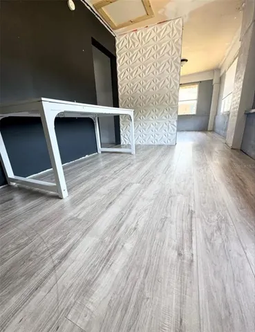 a view of a livingroom with wooden floor and a ceiling fan