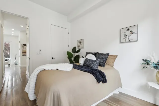 a bedroom with bed and flowerpot