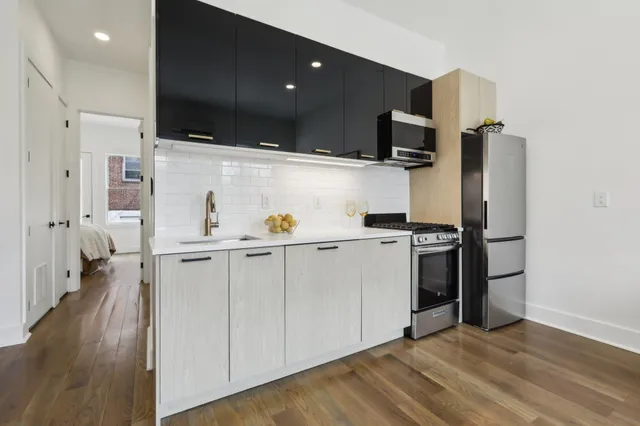a kitchen with stainless steel appliances a refrigerator sink and microwave