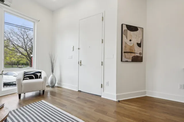 a view of a bedroom with a bed and wooden floor