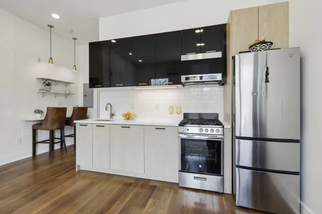 a kitchen with a refrigerator and white cabinets