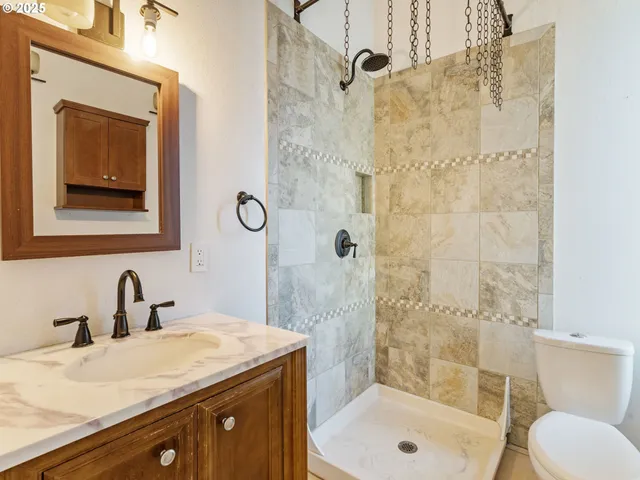 a bathroom with a sink a toilet and shower