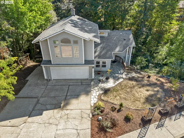 a white house covered with tall trees