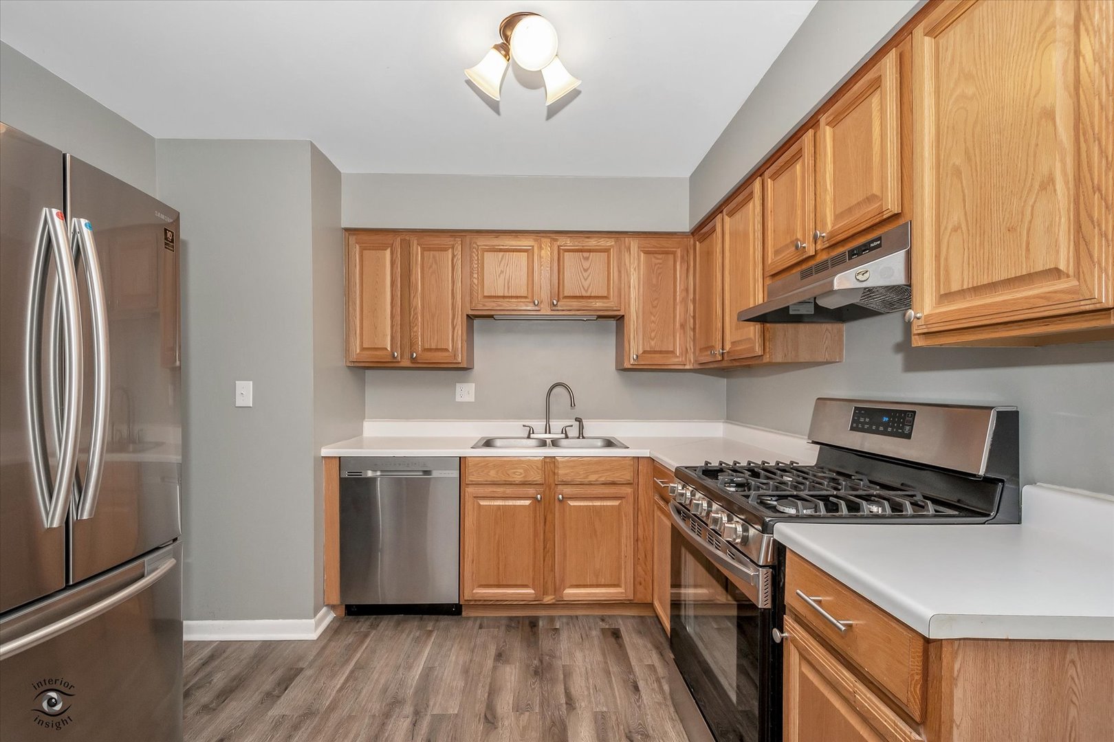 19300 Wolf Road, Unit 11 Mokena, IL 60448 - Photo 9 of 22 a kitchen with stainless steel appliances granite countertop a stove a sink dishwasher and a refrigerator with wooden floor