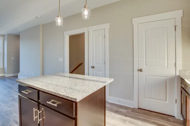 an empty room with kitchen appliances and wooden floor