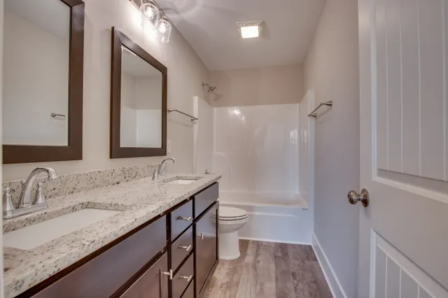 a bathroom with a granite countertop sink tub double and mirror