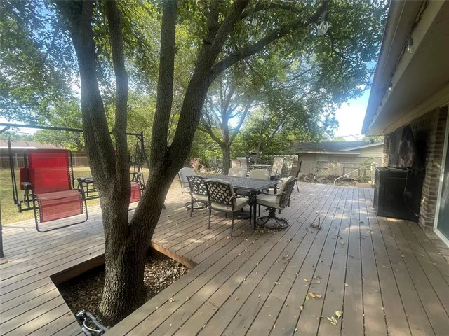 an outdoor sitting area with couch and wooden floor