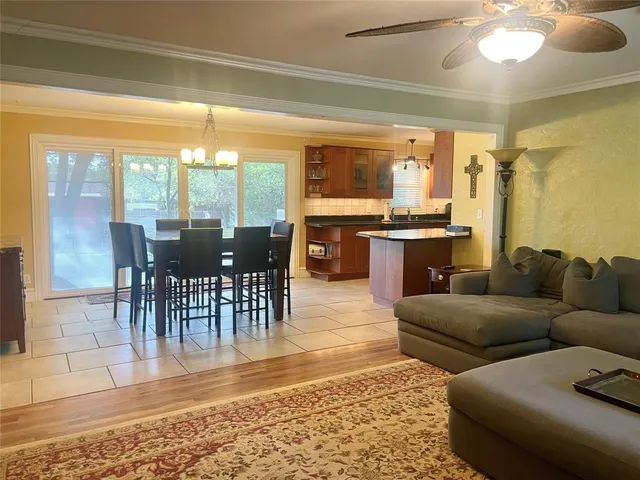 a living room with furniture a large window and dining table