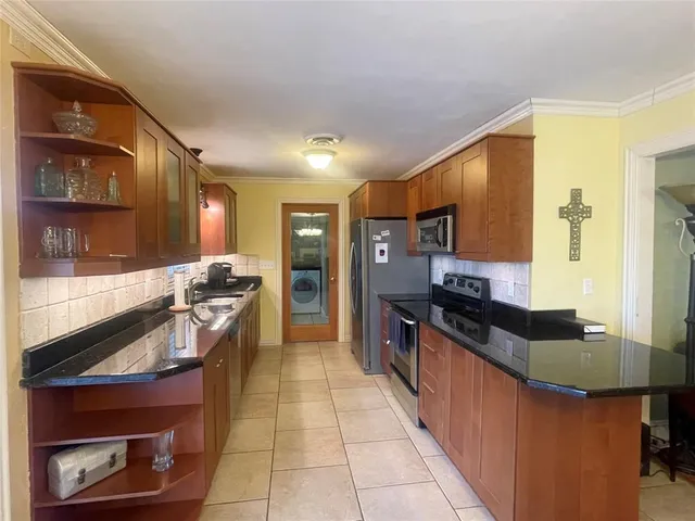 a kitchen with stainless steel appliances granite countertop a stove a sink and a refrigerator