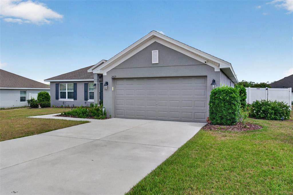 2429 Twin Lake View Road Winter Haven, FL 33881 - Photo 3 of 37 a front view of a house with a yard and garage