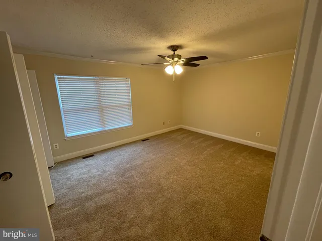 an empty room with closet and ceiling fan